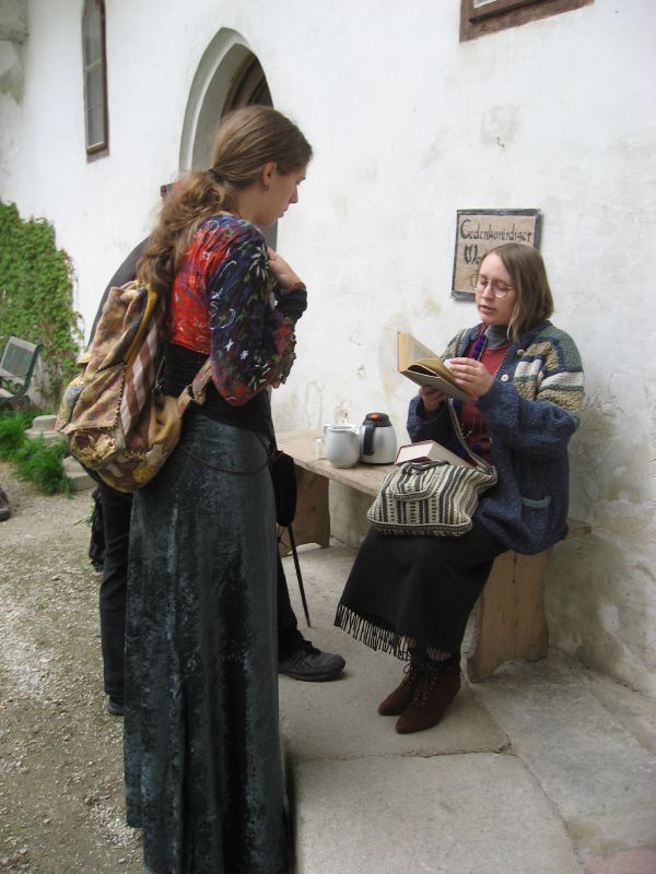 Priestess of Nasn (God of Curiosity)  in discussion with Priestess of Entah